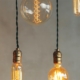 Illustration LED-belysning: Hängande LED-lampor i retro stil framför betonggrå vägg.