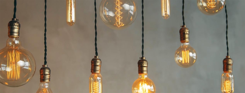 Illustration LED-belysning: Hängande LED-lampor i retro stil framför betonggrå vägg.